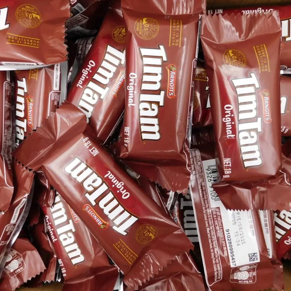 Stack of Tim Tam Original chocolate bars in red packaging.